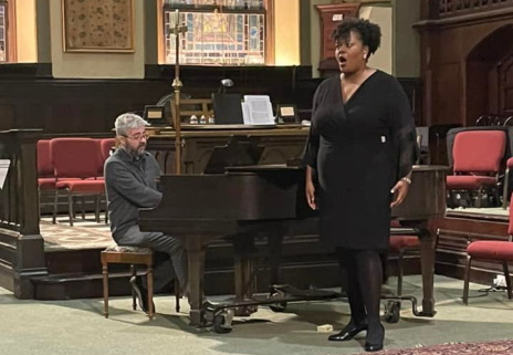  Singer standing at the piano with pianist